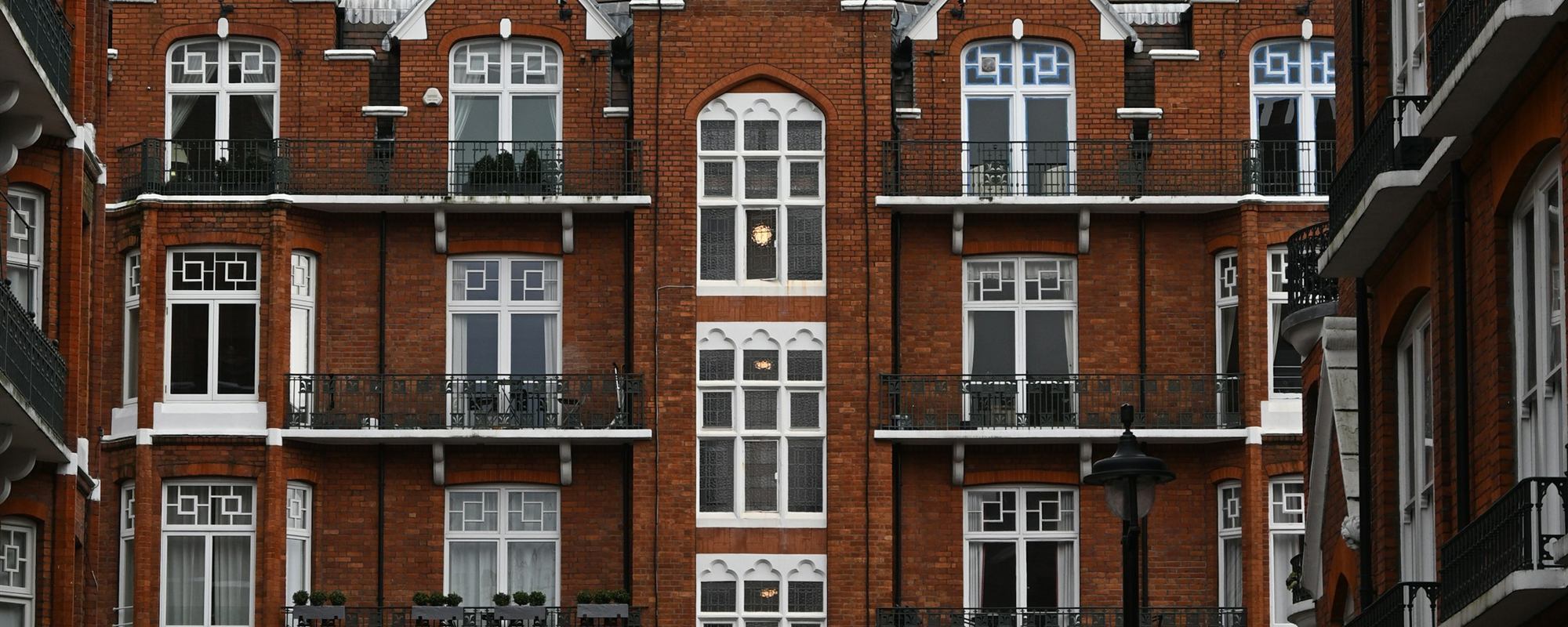 A red-brick Victorian mansion block with iron balconies