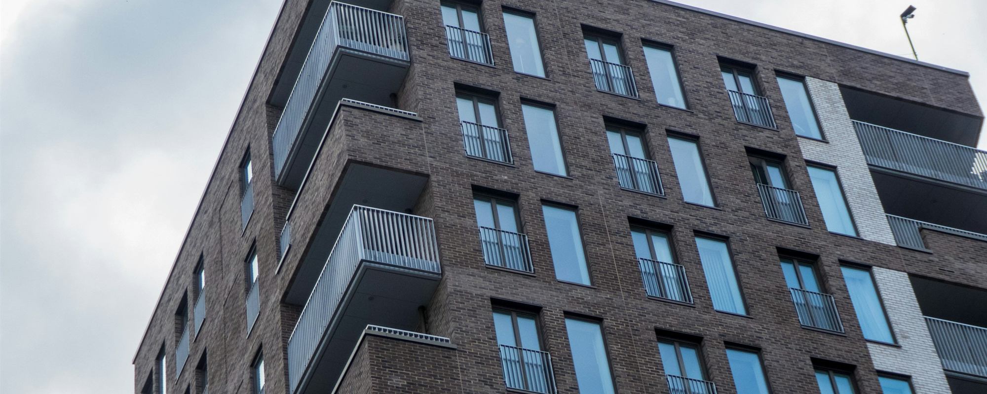 A modern brick residential apartment block with balconies
